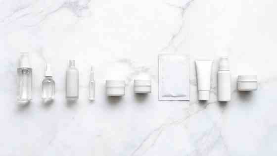 Flat lay of ten Korean skincare products arranged in numbered order on a white marble surface