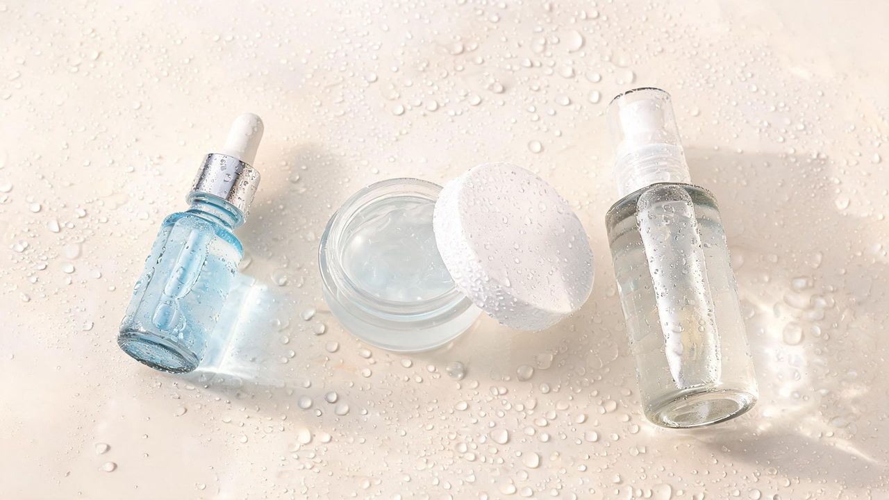 Dewy Korean hydration skincare products with water droplets on glossy surface